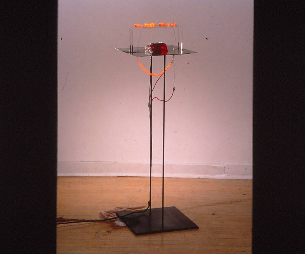 A. metal stand with electrical wiring and a red object