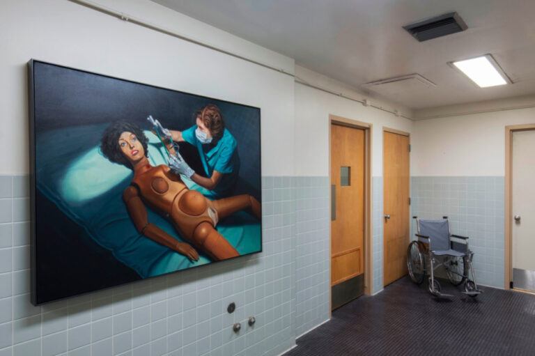 A hospital room with a painting of a human doll on an operating table