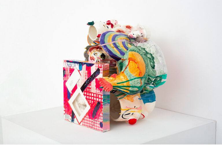 A colorful sculpture featuring an Artforum edition with a Laura Owens painting