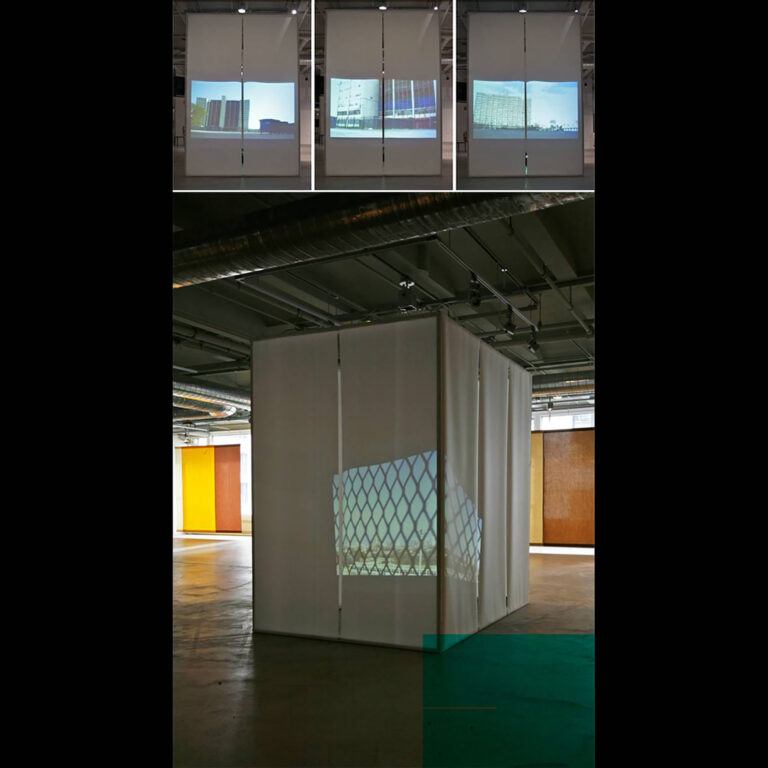 An installation view containing projections of facades and a wire fence