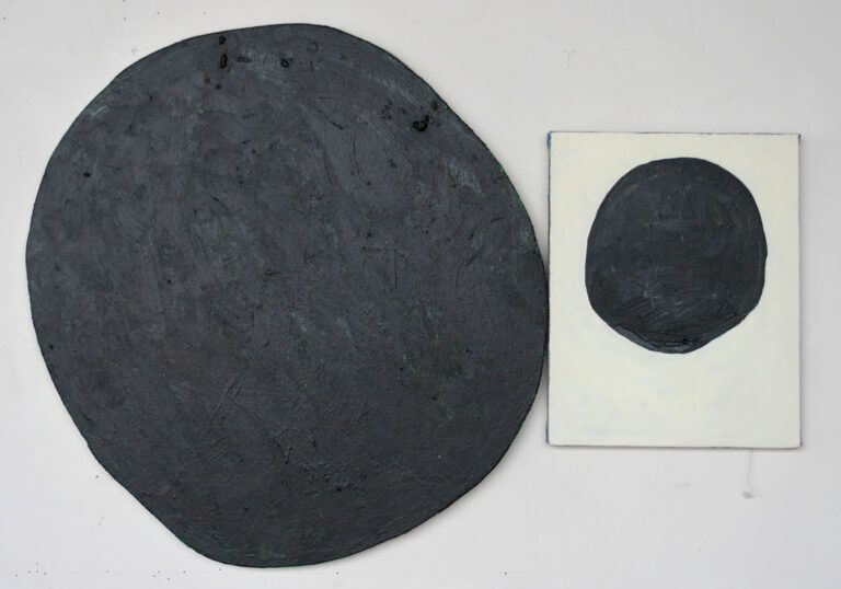 A flat irregular round slab beside a rectangular slab with a circle painted on it