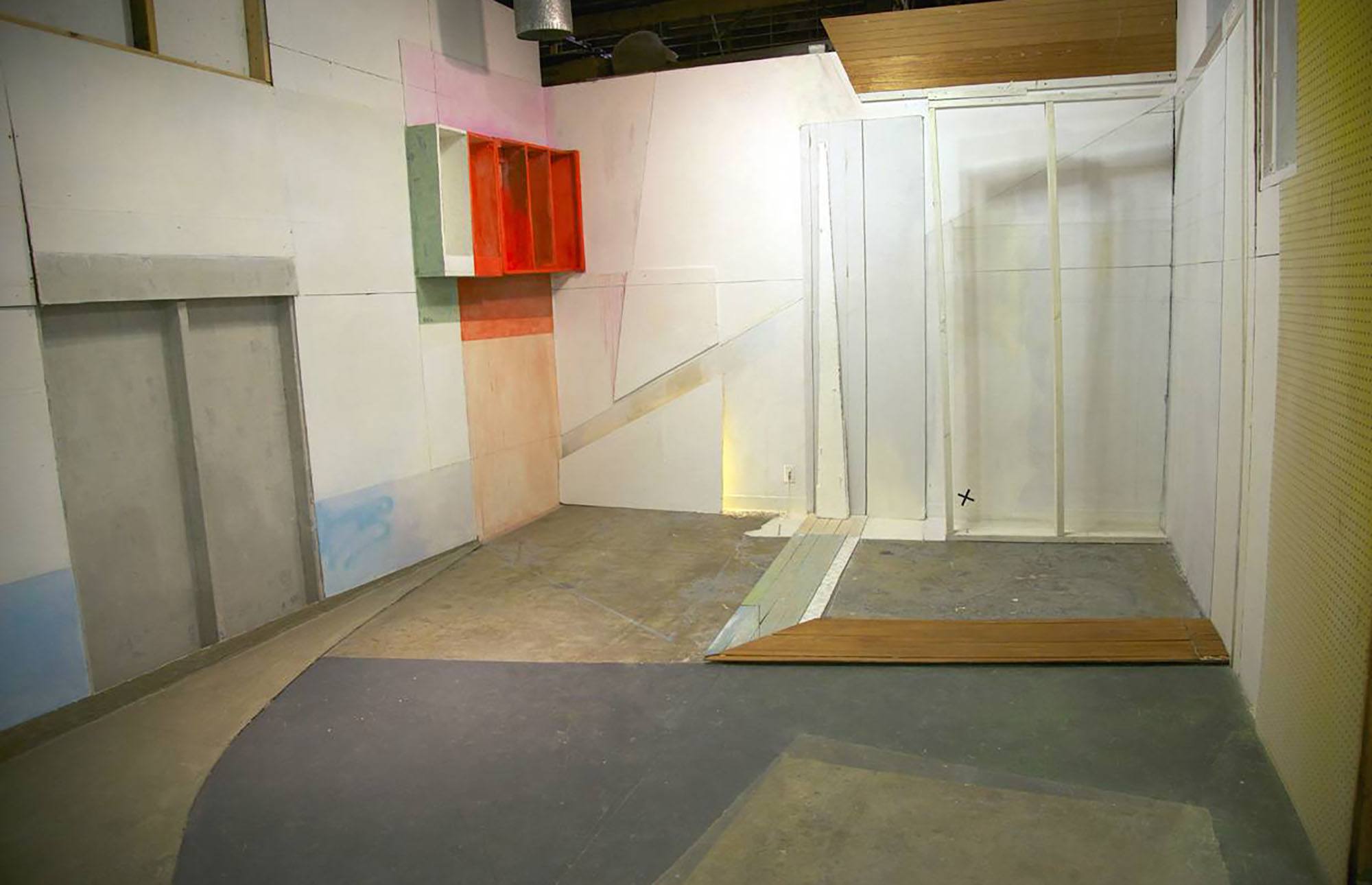An installation image of a gallery space with architectural elements added and cut from the walls