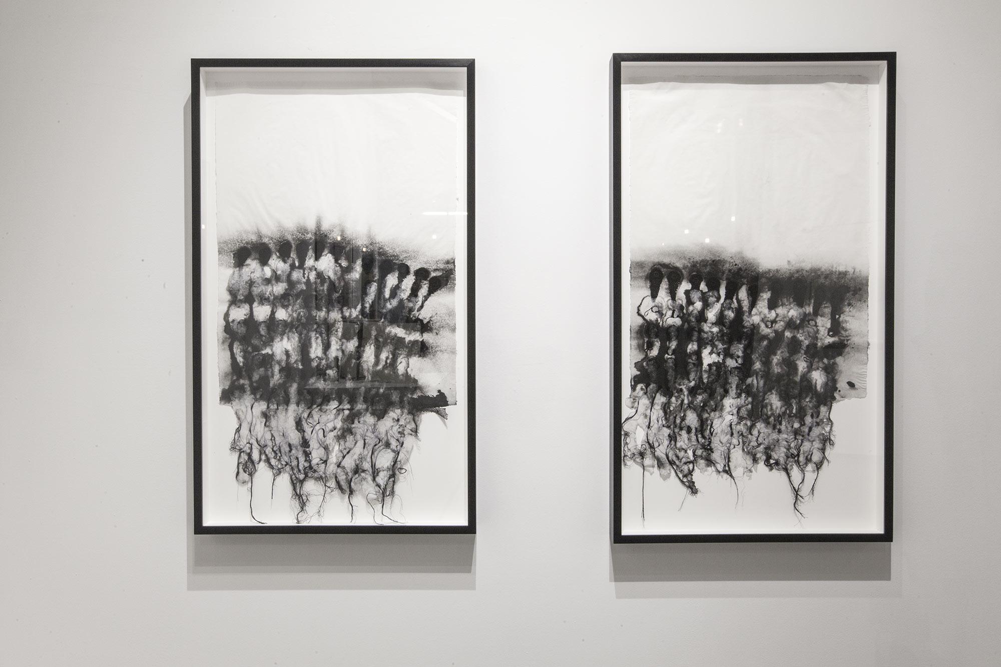Two abstract paintings in black and white hung beside one another