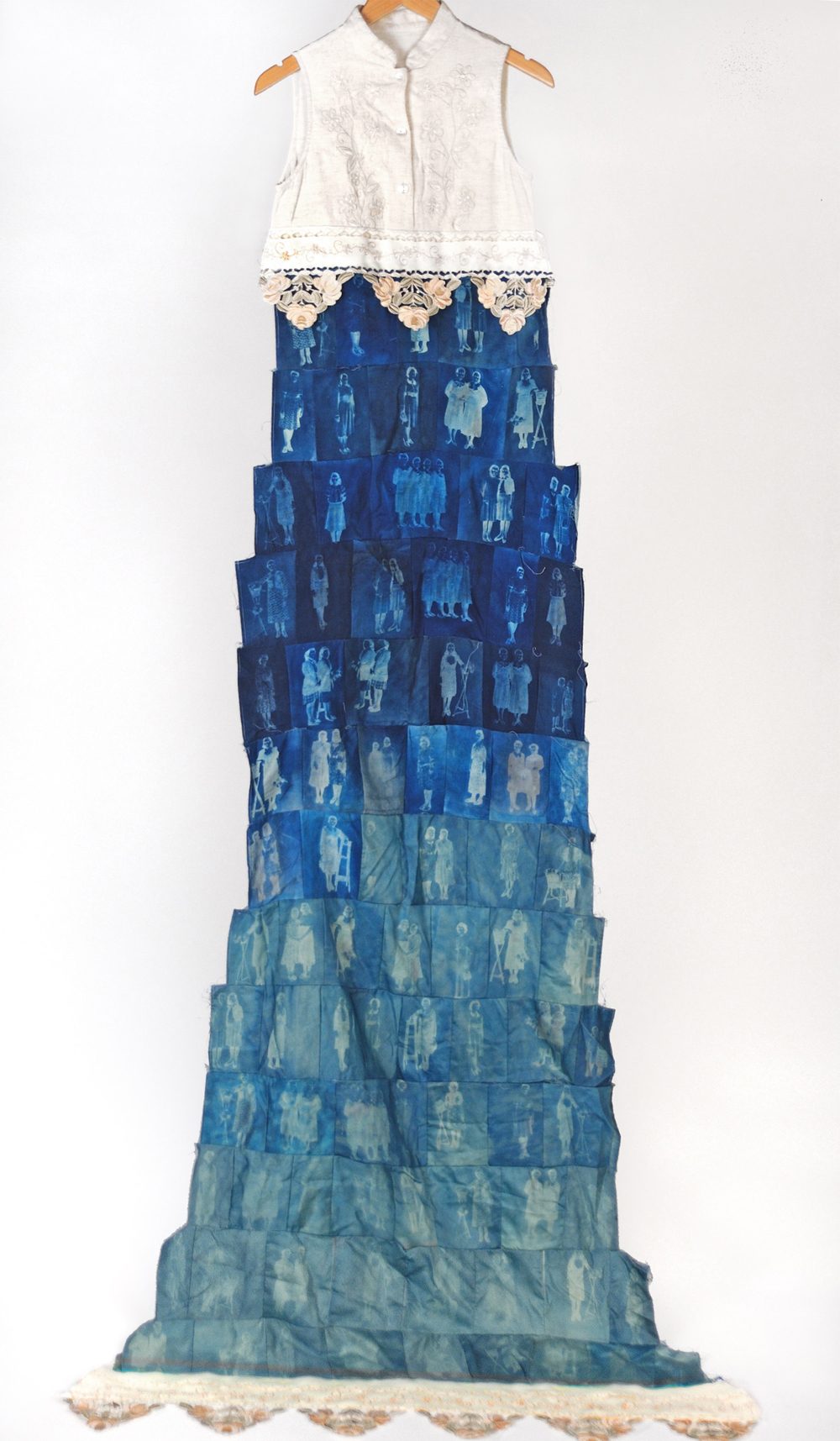 A dress with a white top, and skirt constructed of rows of cyanotypes of illegible figures
