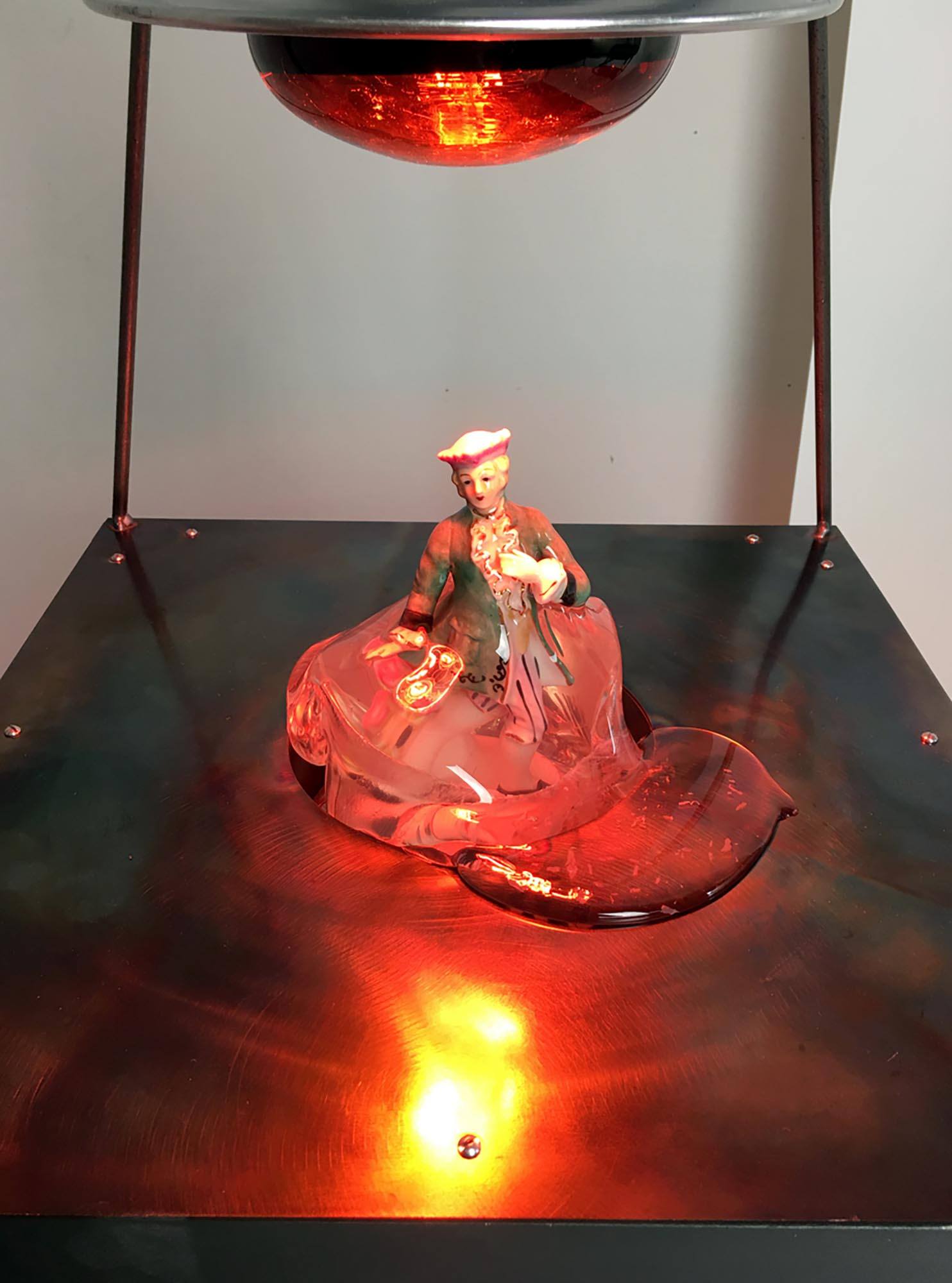 A melting doll of a woman under a red lamp