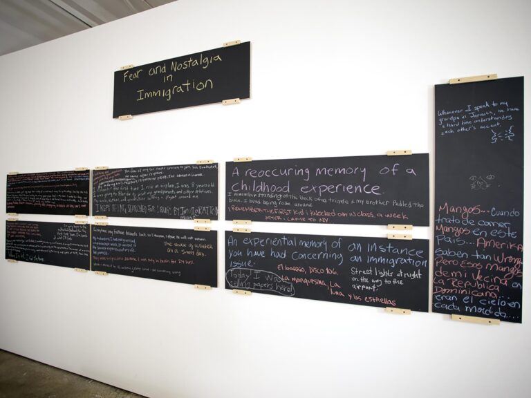 chalk boards on a wall with text written on them. The top one reads "Fear and nostalgia in immigration"