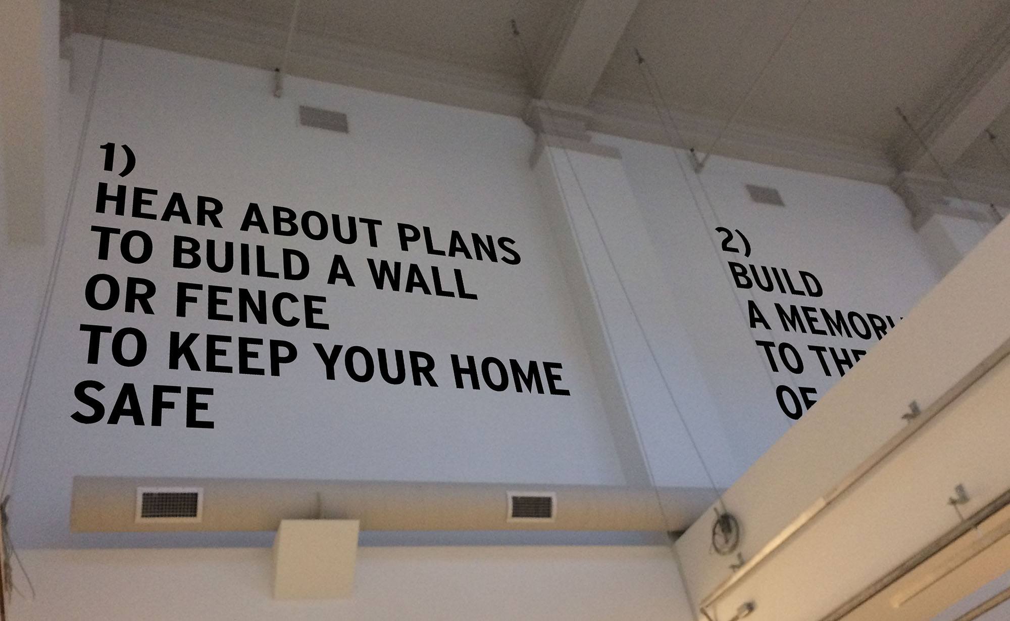 Text printed on a wall that reads "1) Hear about plans to build a wall or fence to keep your home safe"