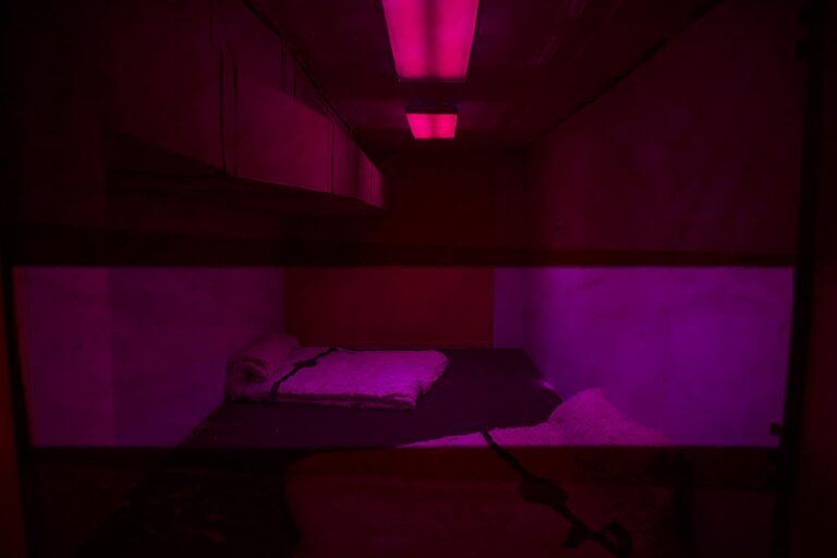 A pink illuminated room with a mattress on the floor