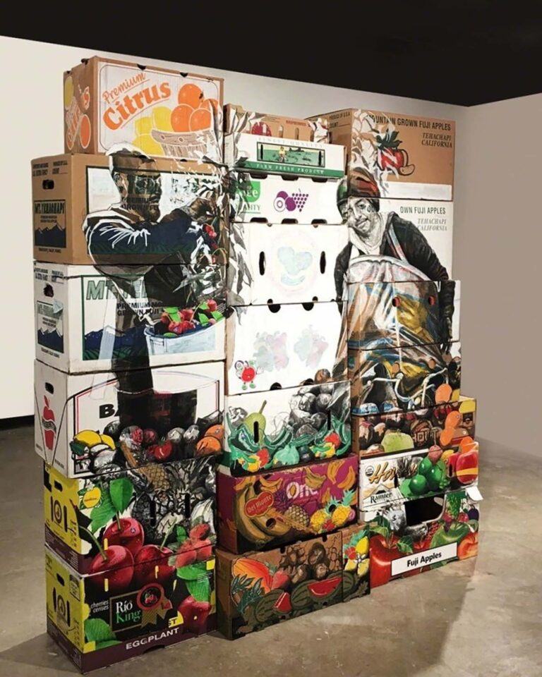 Painted produce boxes with portraits of farmworkers arranged in a tower