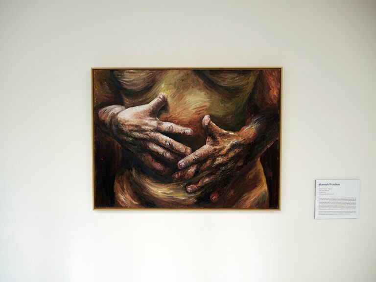 An installation image showing a painting of a woman's torso