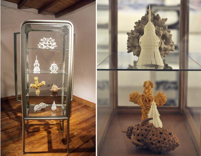 Small sculptures of natural and architectural objects on a glass and metal shelf