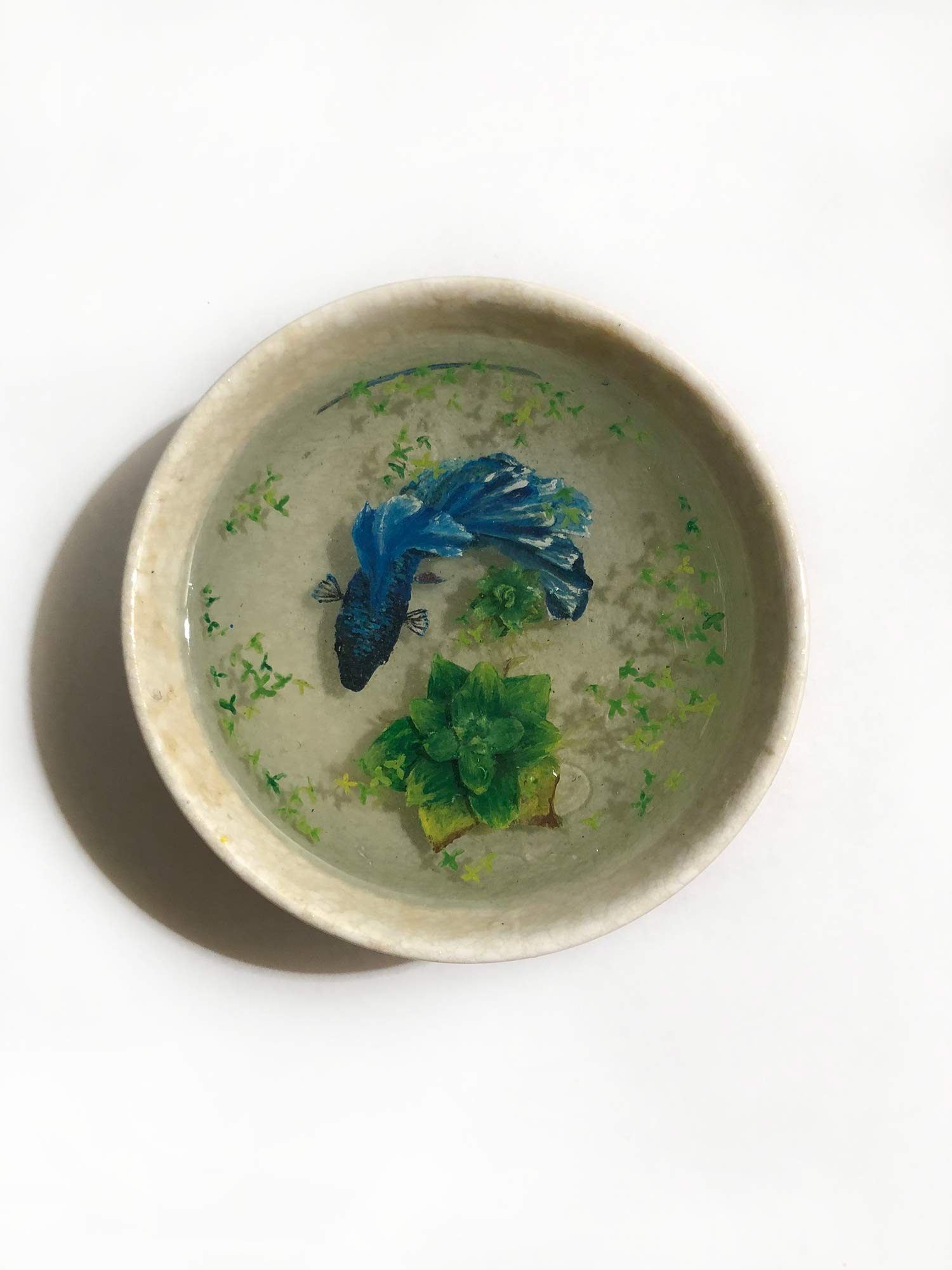 A blue fish swimming in a bowl