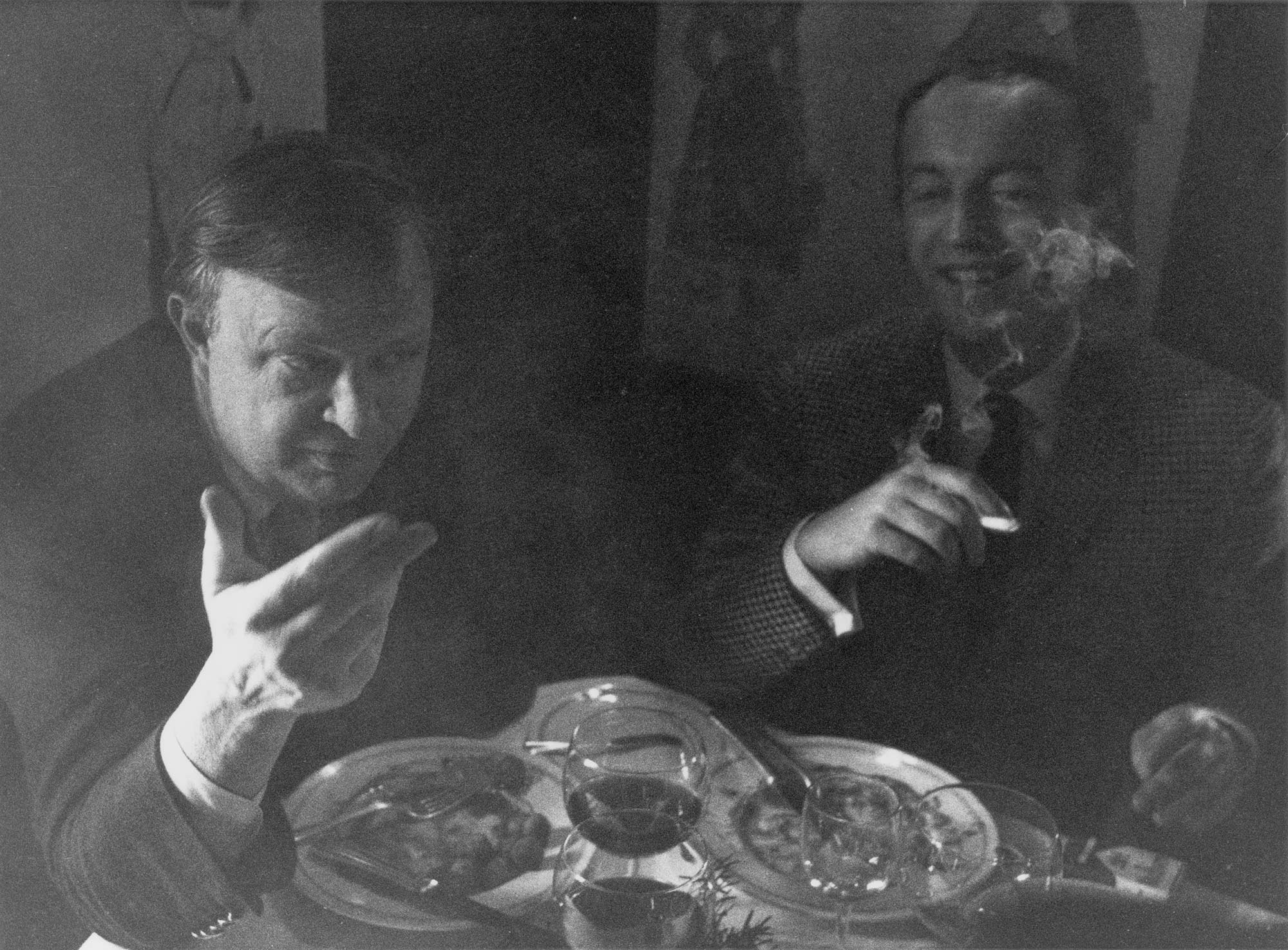 Motherwell and Frank O’Hara smoking cigarettes at a dinner table, 1965