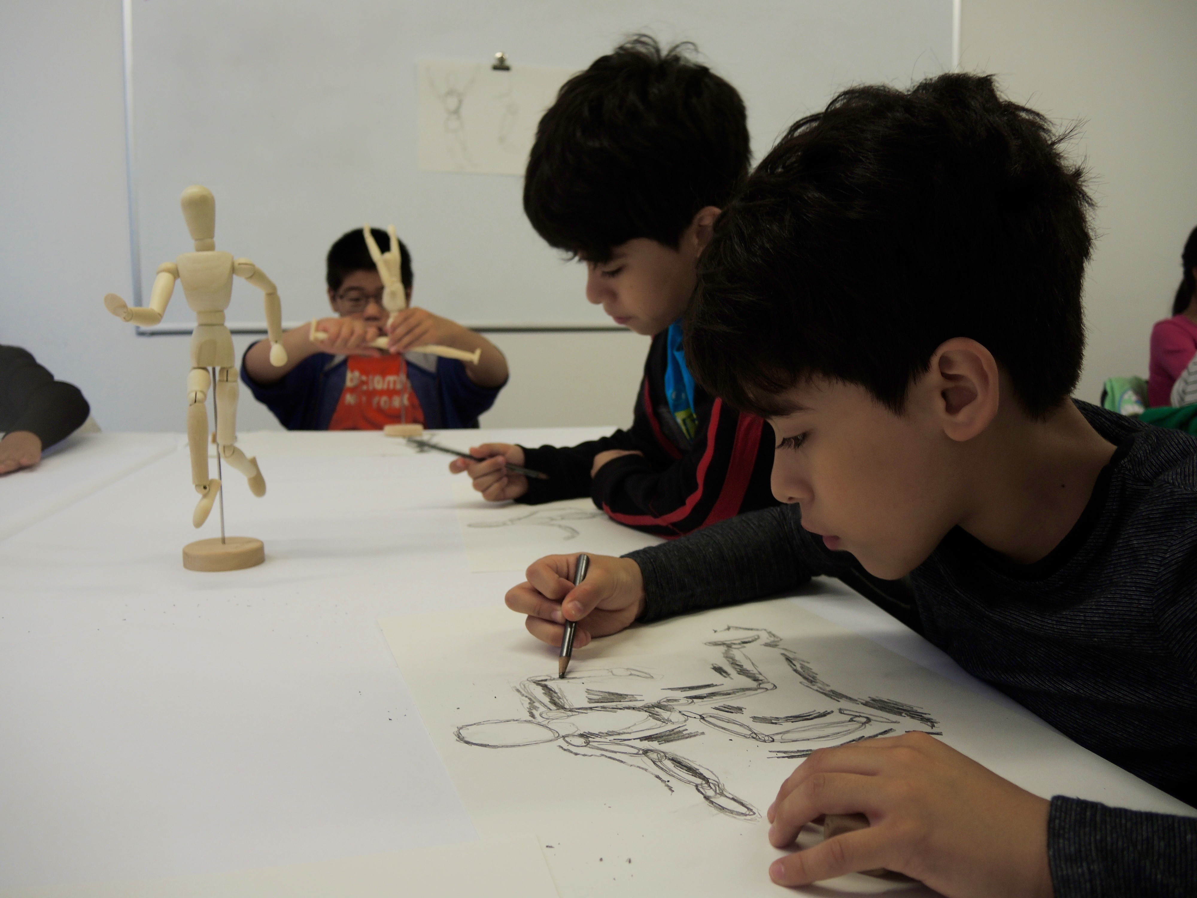 Children sketching an artist mannequin