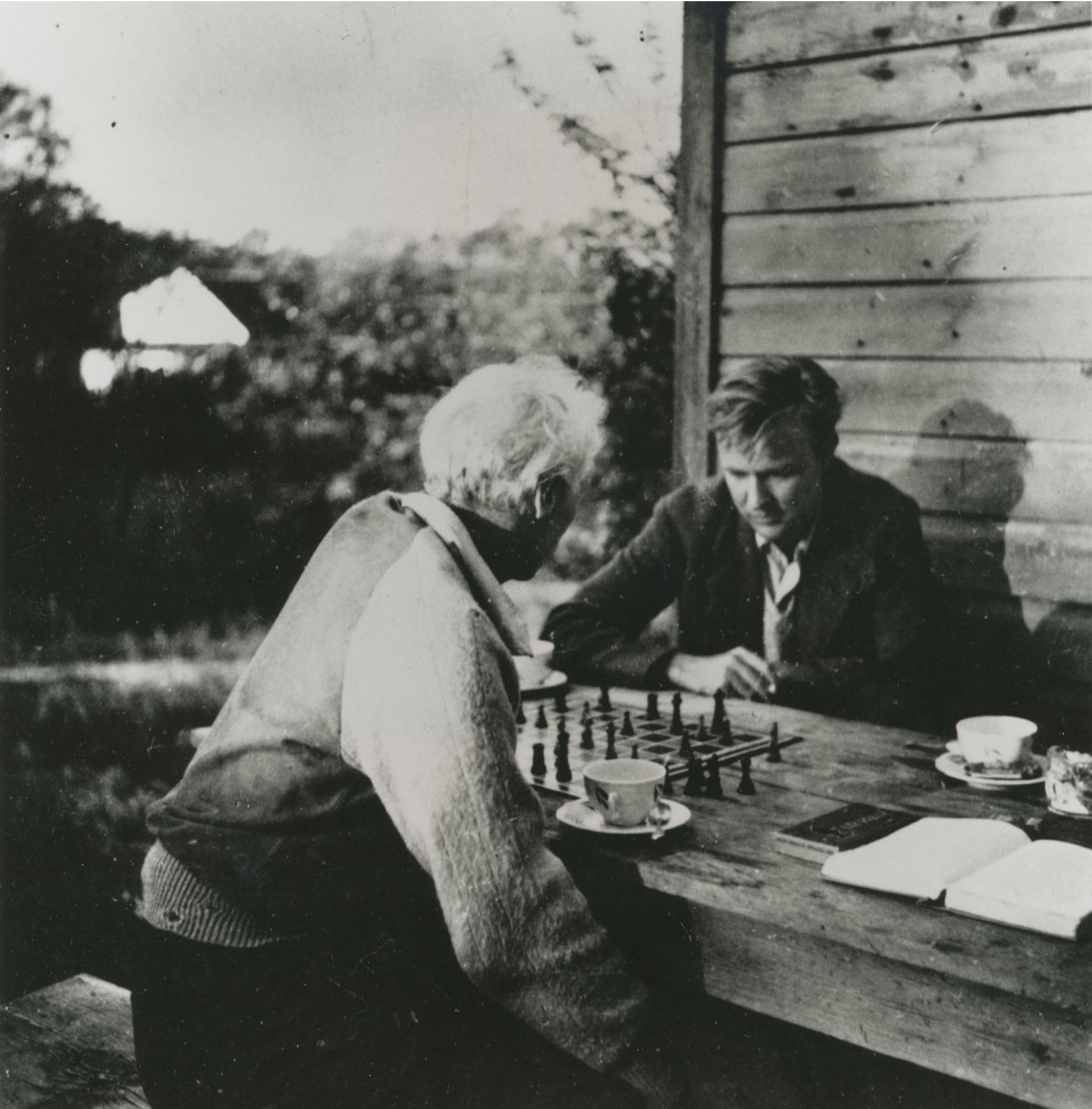 Robert Mothwerwell and Max Ernst playing chess at an outdoor table