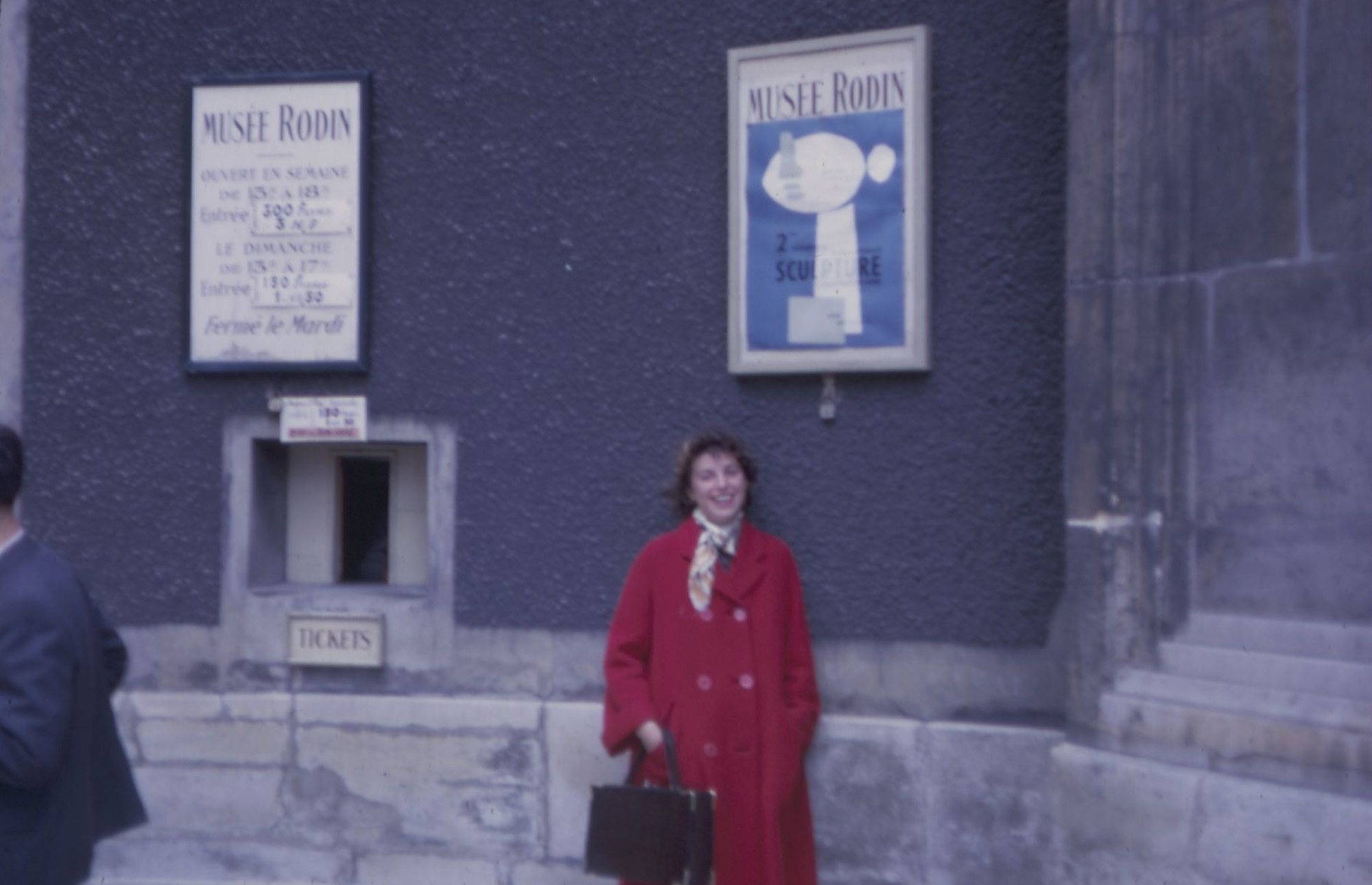 Helen Frankenthaler smiling in a red coat outside the Musee Rodin, Paris, 1961