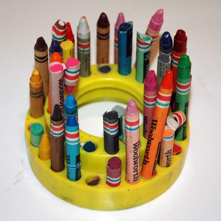A round stand holding a variety of used crayons, some broken