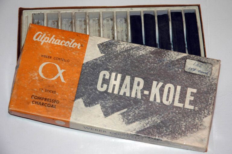 A used 12 pack box of Alphacolor Char-Kole, with seven pieces missing