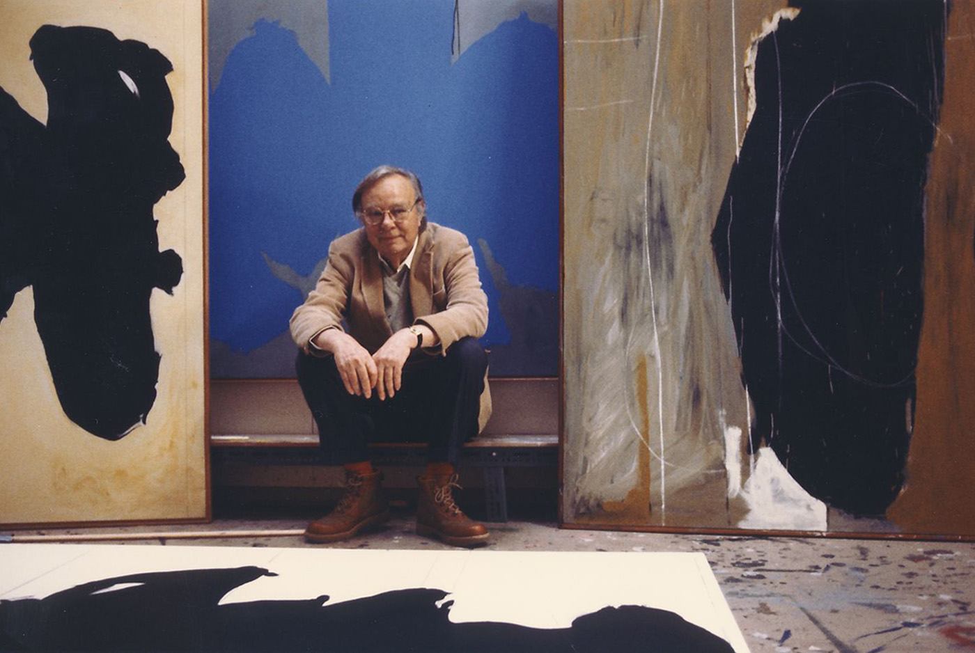A portrait of Robert Motherwell sitting on a bench in his Greenwich studio, 1986