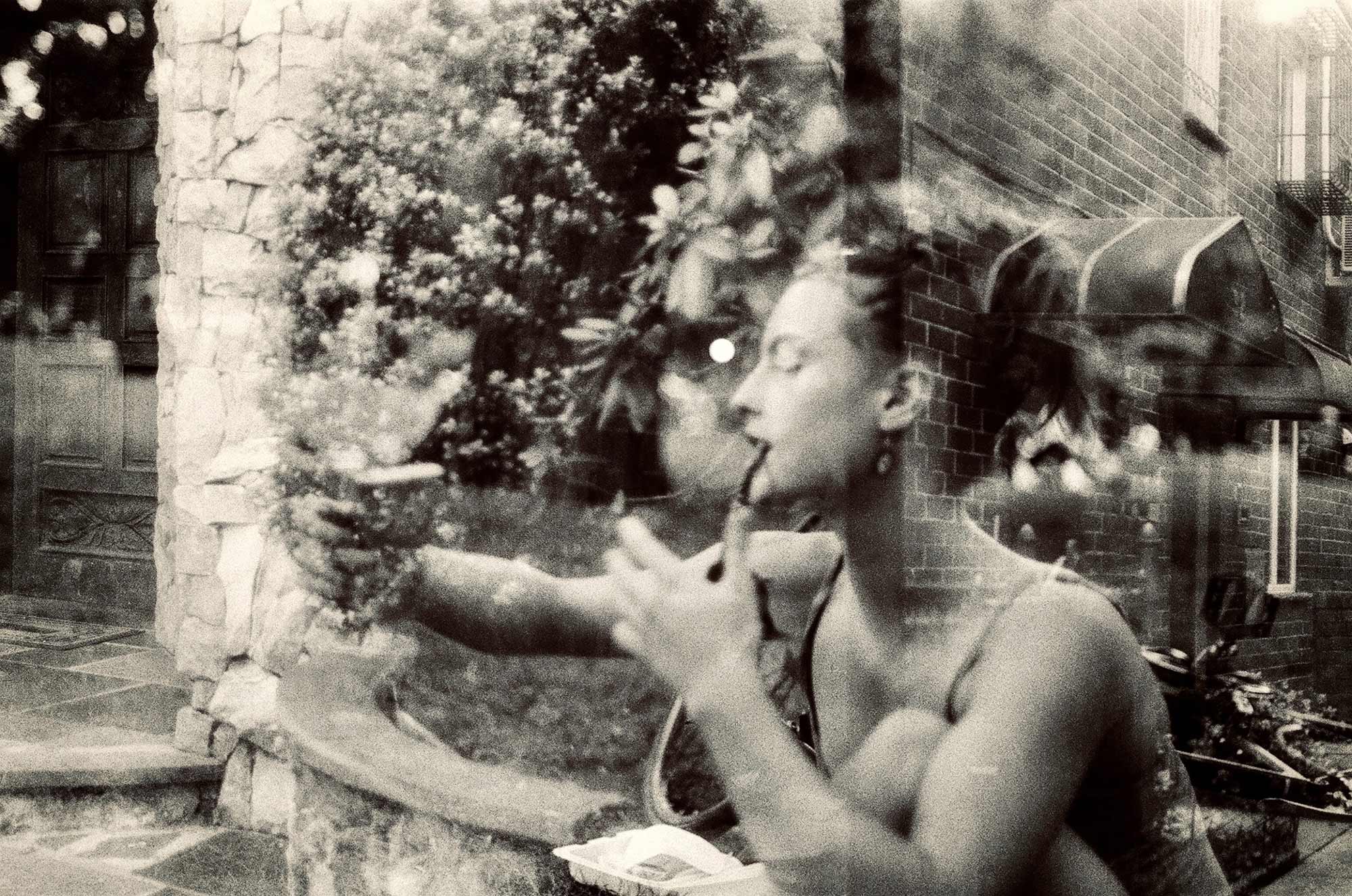 A double exposed photograph of a woman sitting outside