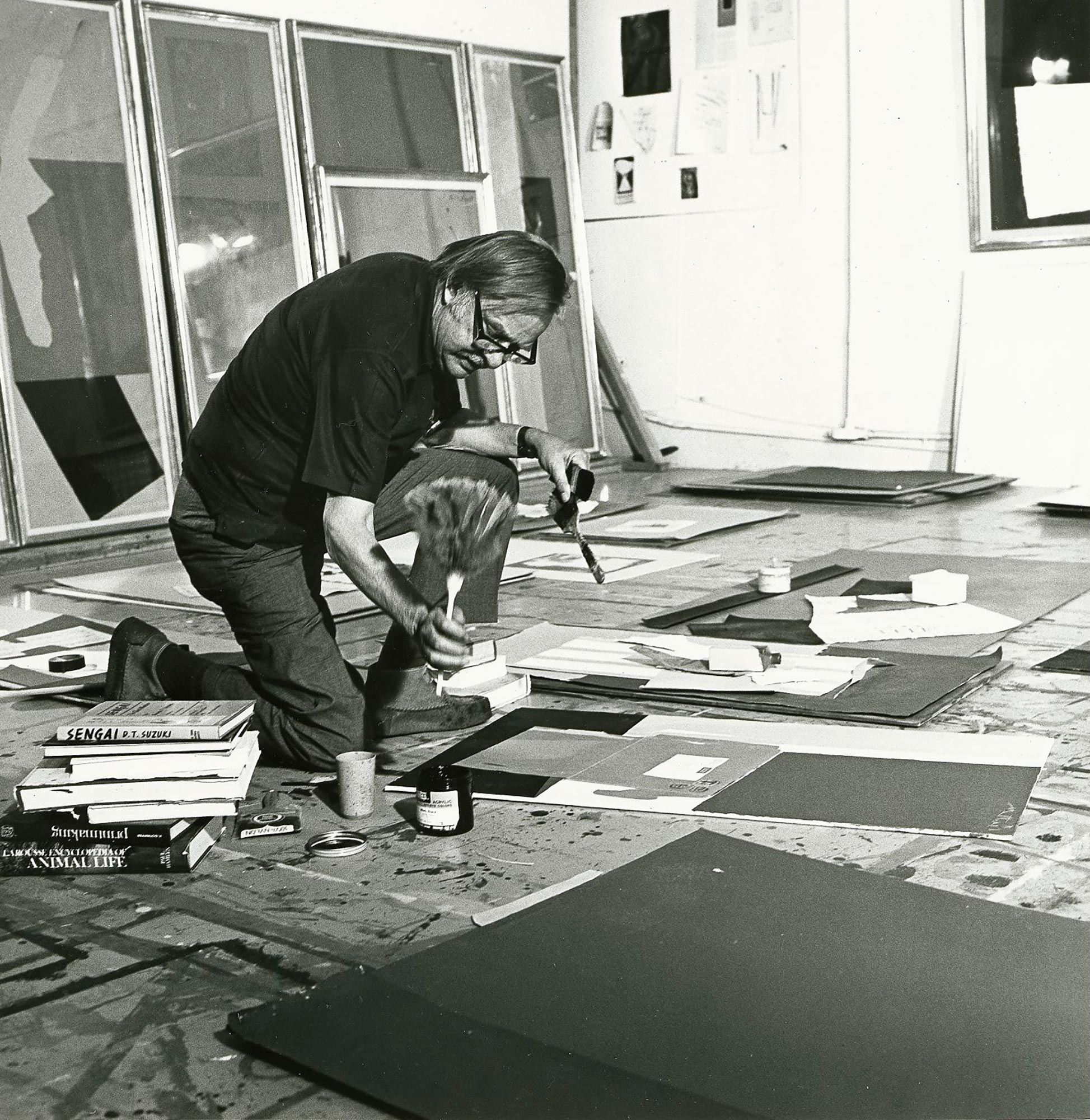 Robert Motherwell painting on the ground in his studio