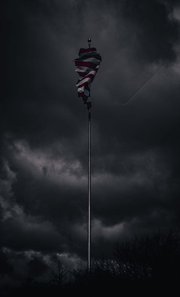 An American flag in a gray sky