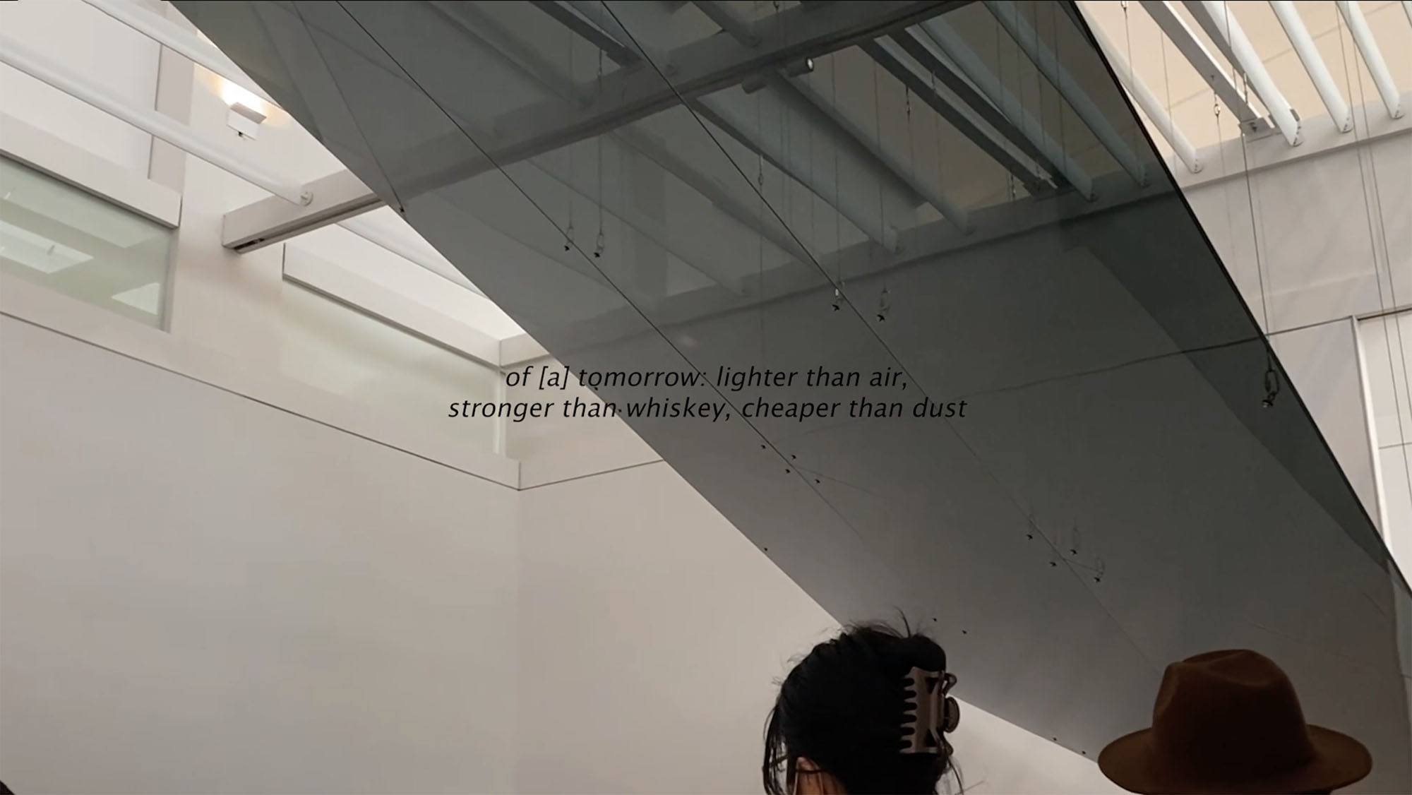 An installation image with text that says "of a tomorrow: lighter than air, stronger than whiskey, cheaper than dust"
