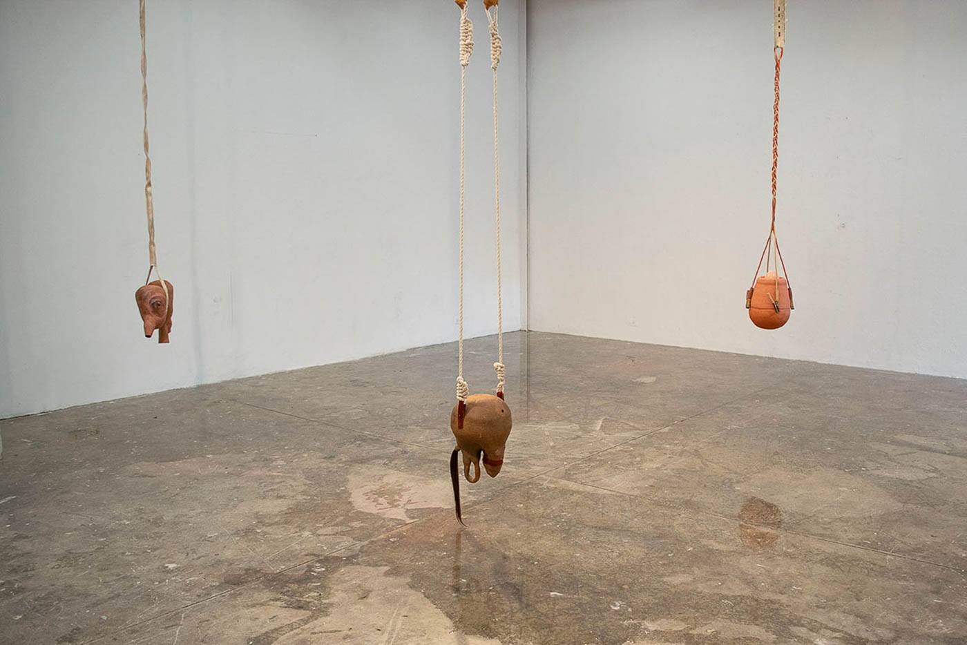 three suspended sculptures in a gallery space